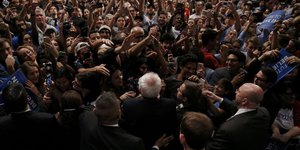 Eine Aufnahme von oben auf Bernie Sanders umringt von Menschen, die ihn fotografieren