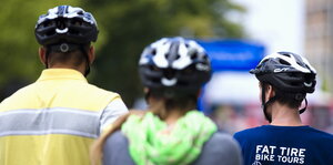Radfahrer ziehen sich Sicherheitsbekleidung, Helm, Warnweste, vor Beginn  einer Radtour