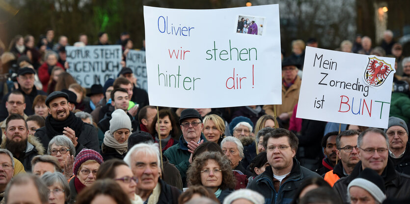 Eine Menschenmenge hält Plakate in die Höhe