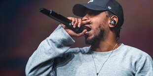 Rapper Kendrick Lamar mit Baseballkappe und Mikro