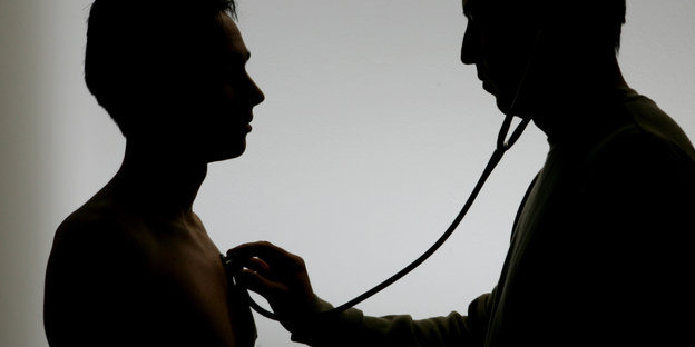 Ein Mann hält ein Stethoskop an die Brust eines anderen mannes