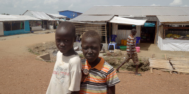 Zwei Jungen stehen in Juba im UN-Flüchtlingscamp im Südsudan auf einem Weg.