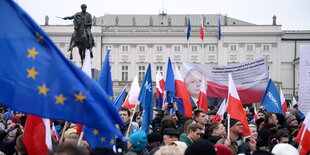 Menschen schwenken Fahnen, darunter die EU-Flagge, vor einem Gebäude