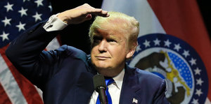 Donald Trump schattet seine Augen mit der Hand