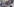 Schwarz angezogene Menschen demonstrieren mit einem rosafarbenen Banner