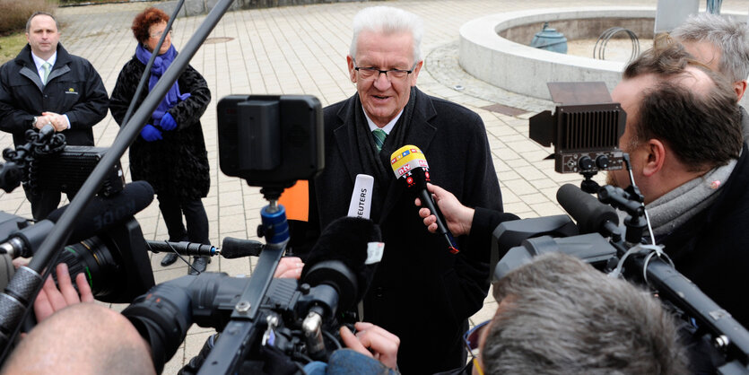 Winfried Kretschmann vor Journalisten und Mikrofonen