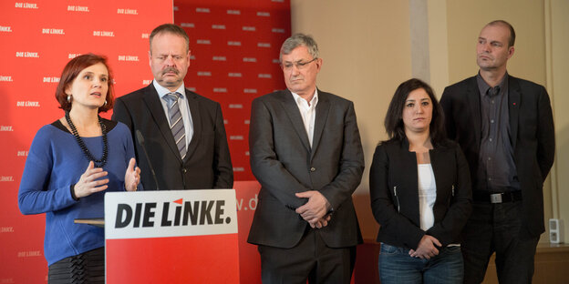 Die Parteispitze und die Spitzenkandidaten der Linken in einer Reihe hinter einem Redner_innenpult mit dem Logo der Partei.