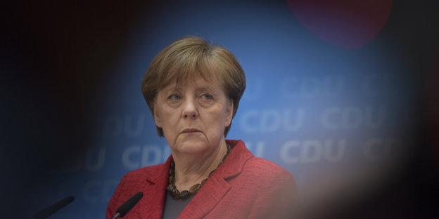 Frau Merkel umgeben von Schatten.