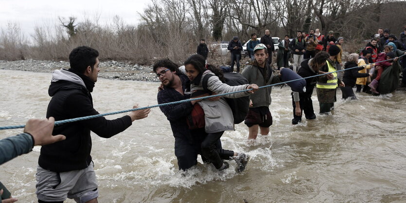 Menschen durchqueren einen Fluss