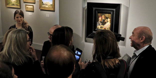Besucher der weltgrößten Kunstmesse in Maastricht stehen vor einem Rembrandt-Gemälde