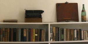 Ein regal mit Büchern und einer Schreibmaschine