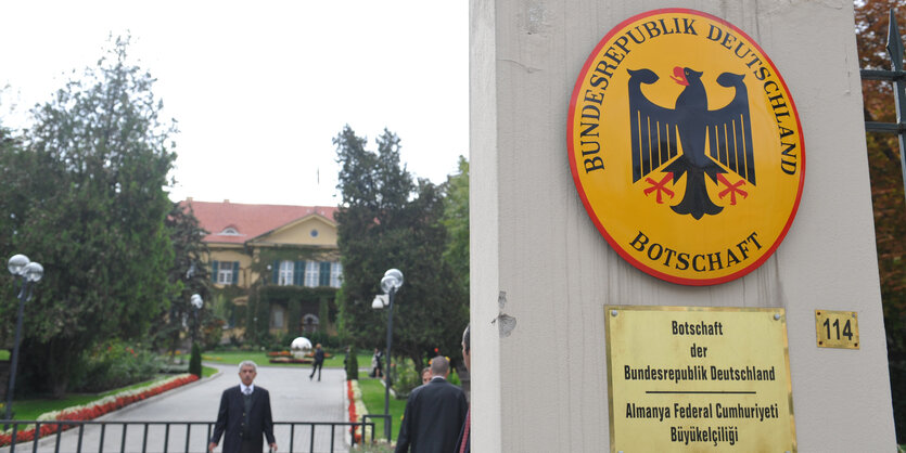 Ein Schild mit dem Wappen der Bundesrepublik Deutschland auf einer Steinsäule.