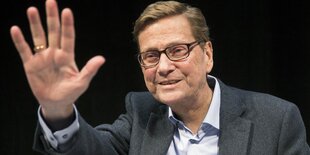 Ein Mann mit Brille winkt in die Kamera. Es ist Guido Westerwelle