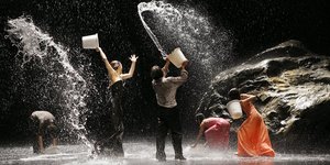 Tänzer*innen werfen mit Wasser um sich