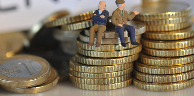 Zwei Figuren sitzen auf Euromünzen