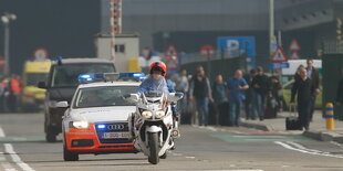 Polizeiwagen und Menschen auf einer Straße