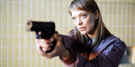 Eine Frau, Heike Makatsch, zielt mit einer Pistole