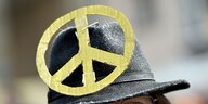 Ein Peace-Zeichen ist an einem schwarzen Hut befestigt.