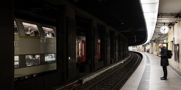 Ein Mann wartet auf einem leeren Bahnsteig im Hauptbahnhof Brüssel Ein Mann wartet auf einem leeren Bahnsteig im Hauptbahnhof Brüssel