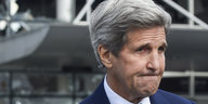 Ein Mann mit grauem Haar, John Kerry, presst die Lippen aufeinander
