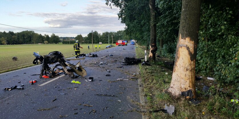 Rettungskräfte nach einem Unfall auf einer Straße, Blech liegt herum