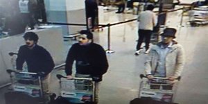 Drei Männer schieben am Flughafen Gepäckstücke