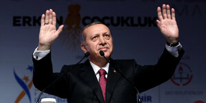 Staatspräsident Recep Tayyip Erdoğan hebt die Hände hoch