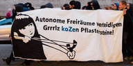 Menschen tragen ein Transparent mit der Aufschrift "Autonome Freiräume verteidigen - Grrrlz koZen Pflastersteine"