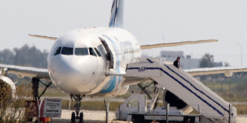 Ein Flugzeug der Airline Egyptair steht auf dem Rollfeld. Eine Person verlässt das Flugzeug über eine Treppe.