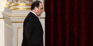 Ein Mann im schwarzen Anzug, Francois Hollande, ist von der Seite zu sehen