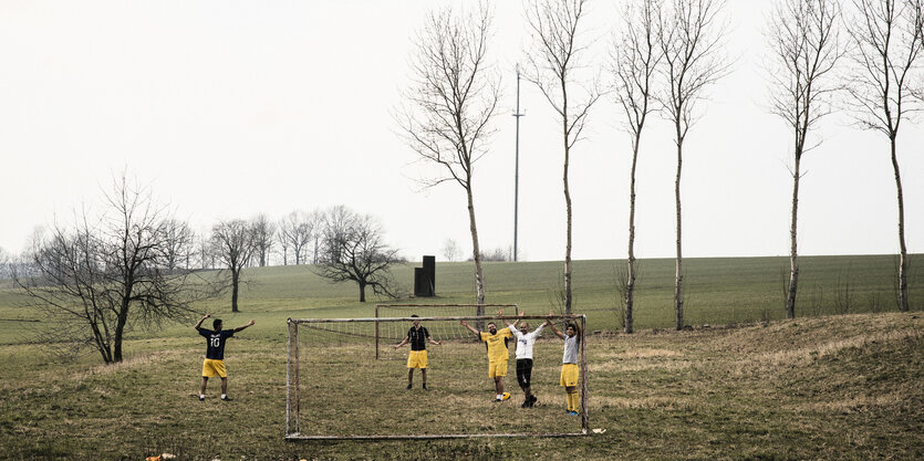 Fußballspieler auf einem unebenen Platz