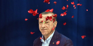 Ein Mann, Erdoğan, auf den Rosenblätter regnen