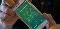 Der grüne Sperrbildschirm eines iPhones mit Nummernblock