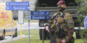 Ein Mann in Militäruniform steht mit Waffe auf der Straße