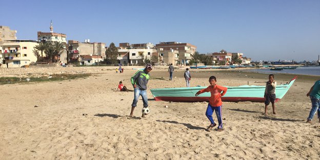 Kinder spielen am Strand des Dorfes.
