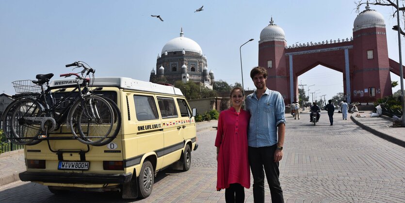 Ein Mann und eine Frau stehen neben einem VW-Bus