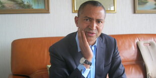 Ein Mann, es ist Moise Katumbi, auf einem Sofa