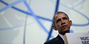 Obama schaut ernst vom Podium