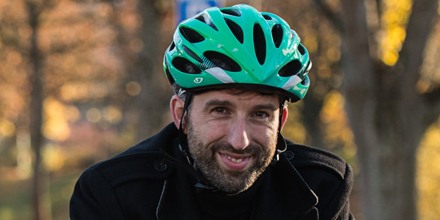 ein Mann mit einem grünen Fahrradhelm