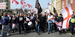 Demonstranten tragen Trommeln und Fahnen mit sich