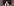 Walter Homolka trägt einen Tallit und steht hinter zwei Mikrofonen