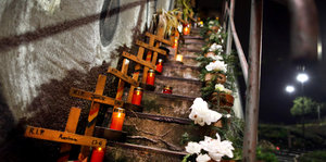 Kreuze und Grablichter auf der Treppe