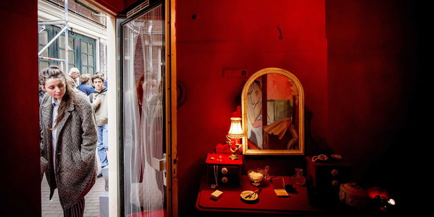 Eine Frau schaut in ein Zimmer mit roten Wänden