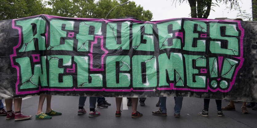 Auf einem Transparent steht „Refugees Welcome“