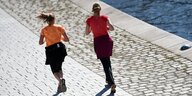 Zwei Frauen von hinten, die an der Spree entlang joggen