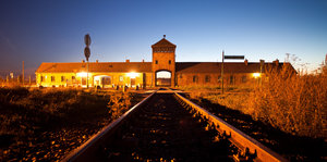 Schienen führen auf das zentrale Gebäude in Auschwitz zu