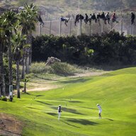 Flüchtlinge Kletern über den Zaun in Melilla, unten spielen Menschen auf einem Golfplatz
