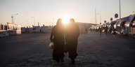 Zwei Frauen im Gegenlicht des Sonnenuntergangs in einem Flüchtlingslager