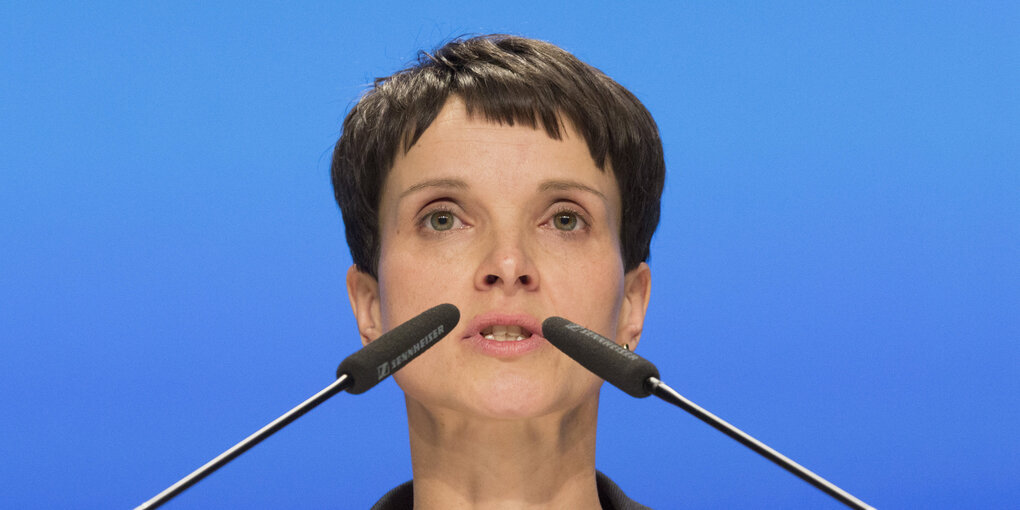 Eine Frau mit zwei Mikrofonen vorm Gesicht, es ist Frauke Petry