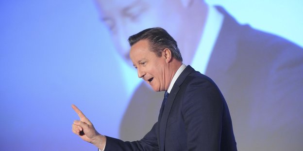 David Cameron vor einer Leinwand, auf der er noch mal vergrößert zu sehen ist.